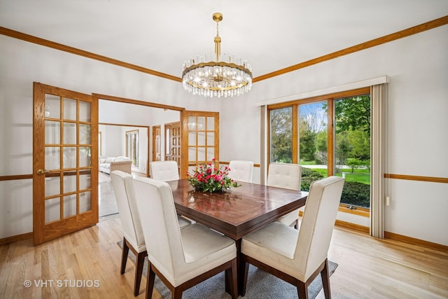 dining room with french doors, light wood-style floors, crown molding, a chandelier, and baseboards