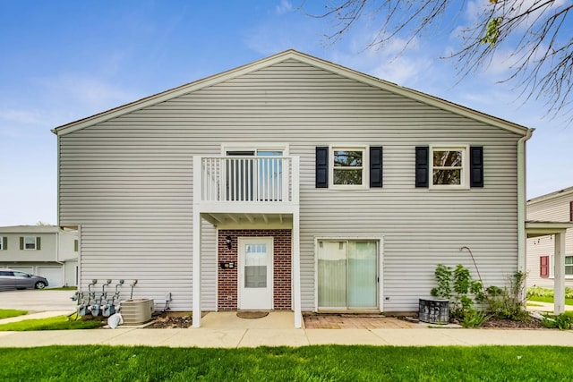 back of property featuring a balcony and central AC