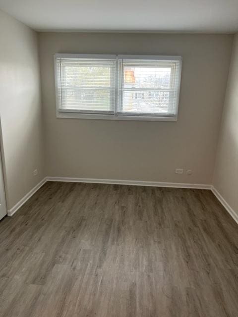 spare room with wood finished floors and baseboards