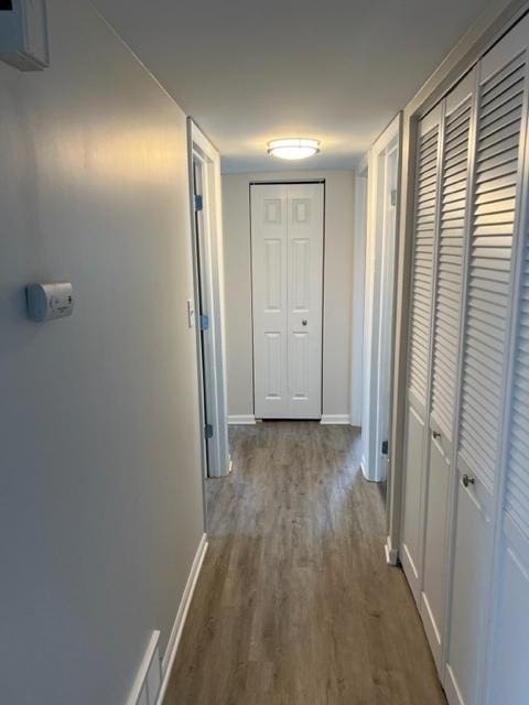 hallway with dark wood-style floors and baseboards