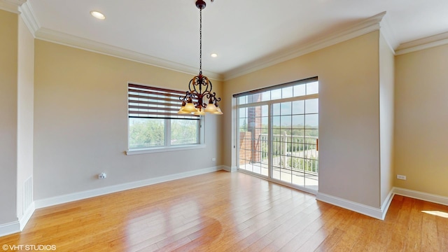 spare room featuring a chandelier, crown molding, wood finished floors, baseboards, and recessed lighting