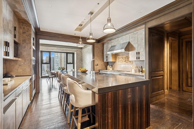 77 E Walton St Unit 25C, Chicago, IL 60611 - kitchen featuring dark wood-style floors, a sink, wall chimney exhaust hood, ornamental molding, and stainless steel gas stovetop