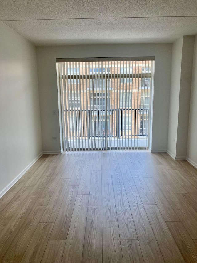 656 Pearson St Unit 608C, Des Plaines, IL 60016 - empty room featuring wood finished floors, a textured ceiling, and baseboards