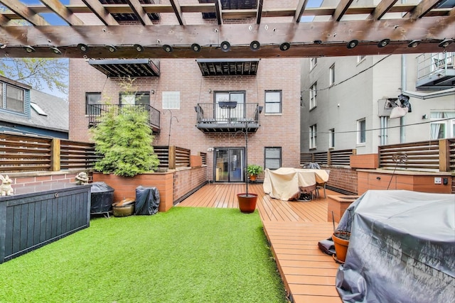 rear view of property featuring brick siding, a pergola, and a wooden deck