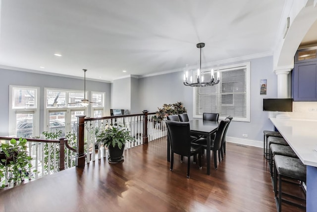 dining area with a chandelier, dark wood finished floors, baseboards, ornamental molding, and a ceiling fan