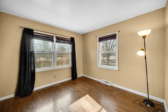 spare room with hardwood / wood-style flooring and baseboards