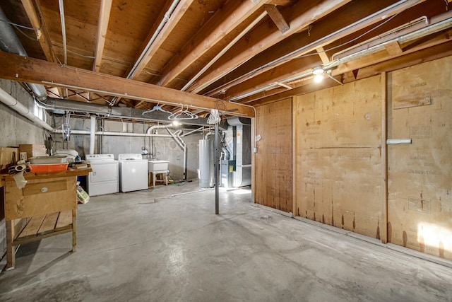 unfinished basement with washer and dryer, water heater, a sink, and heating unit