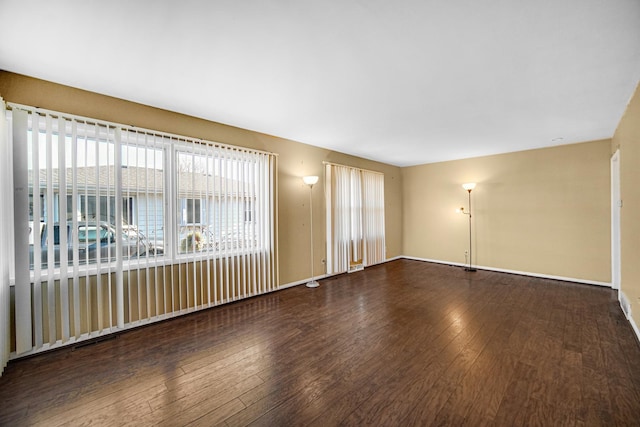 spare room with hardwood / wood-style floors and baseboards