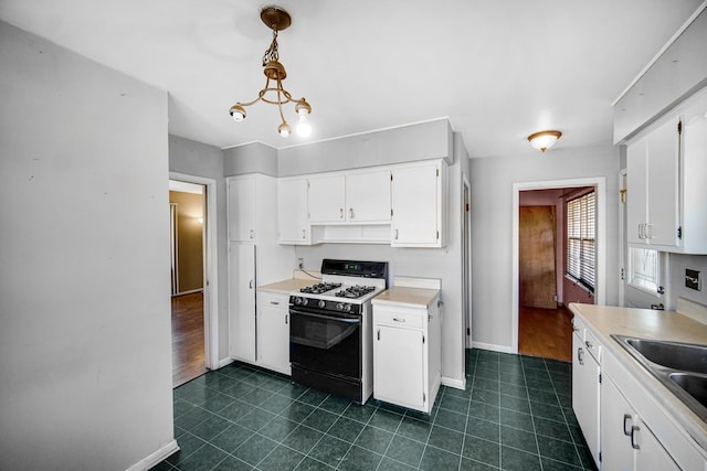 kitchen featuring gas range oven, baseboards, white cabinets, and light countertops