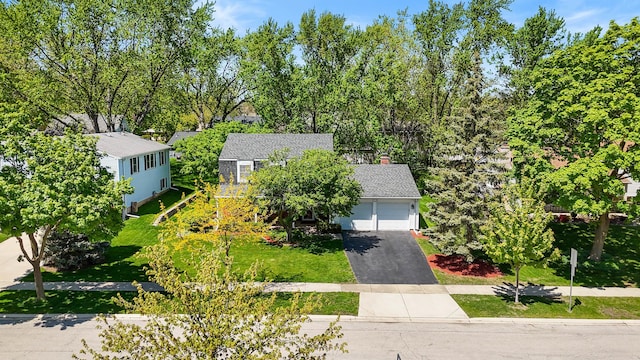 1712 Sutton Ln, Schaumburg, IL 60194 - view of front facade with driveway, an attached garage, and view of wooded area