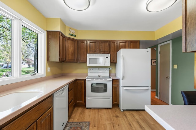 1712 Sutton Ln, Schaumburg, IL 60194 - kitchen featuring white appliances, light wood-style floors, light countertops, and a sink
