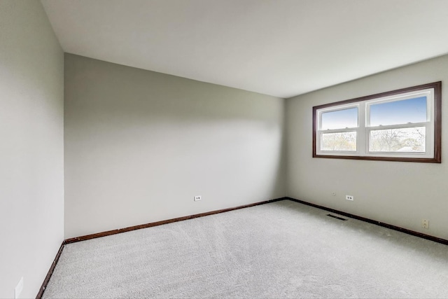 empty room featuring carpet and baseboards