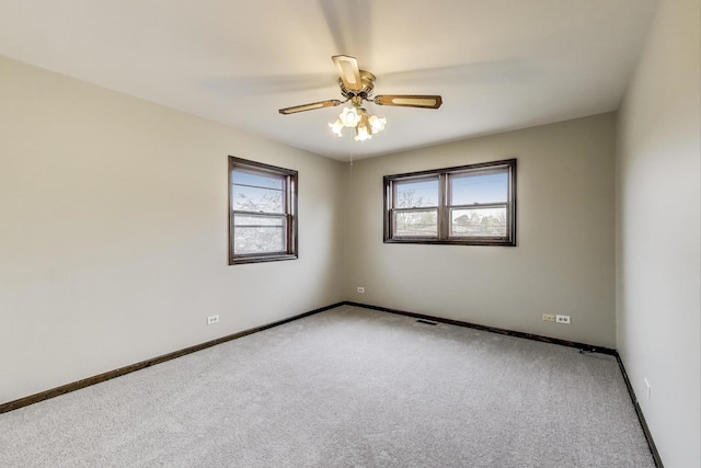 carpeted spare room with baseboards and a ceiling fan