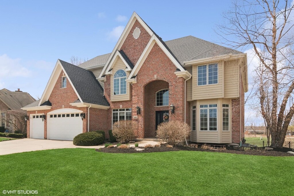 101 Lucy Ct, Lake Zurich, IL 60047 - traditional-style house with brick siding, a front lawn, concrete driveway, a garage, and roof with shingles
