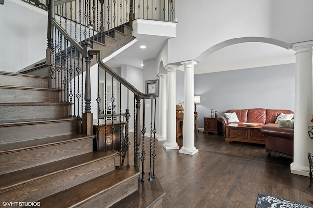 101 Lucy Ct, Lake Zurich, IL 60047 - staircase featuring a towering ceiling, arched walkways, wood finished floors, baseboards, and ornate columns