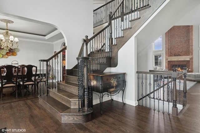 101 Lucy Ct, Lake Zurich, IL 60047 - stairs featuring wood finished floors, a chandelier, baseboards, ornamental molding, and a brick fireplace