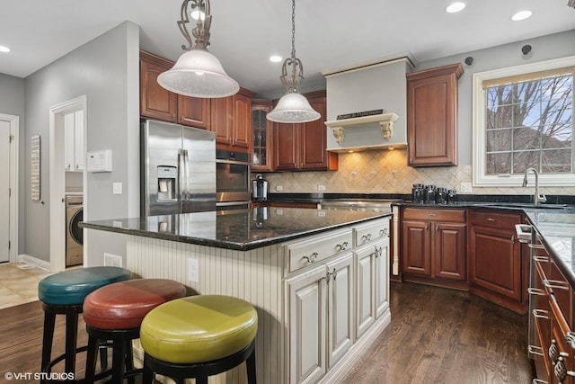 101 Lucy Ct, Lake Zurich, IL 60047 - kitchen with appliances with stainless steel finishes, a sink, washer / clothes dryer, backsplash, and dark wood-style flooring