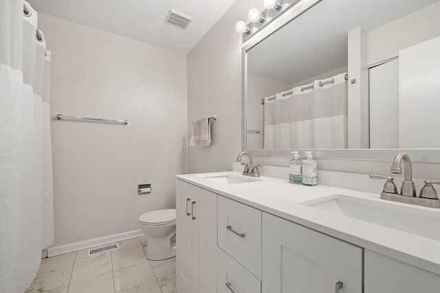 full bath with marble finish floors, toilet, double vanity, and baseboards