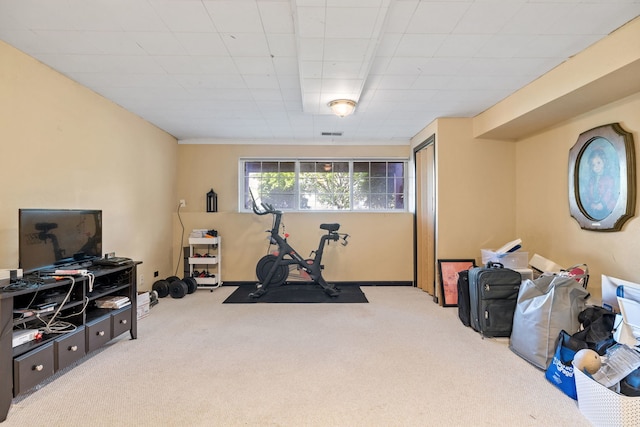 exercise area with carpet floors and a paneled ceiling