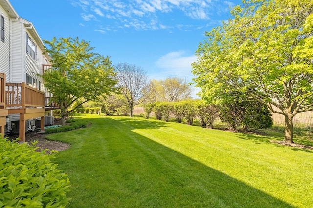 view of grassy yard with a deck