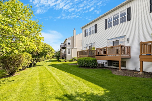 back of property with a lawn, cooling unit, and a deck