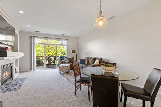 dining room with carpet flooring, a tiled fireplace, baseboards, and recessed lighting