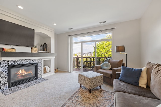 carpeted living area with a tile fireplace, recessed lighting, and baseboards
