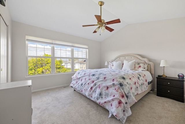 carpeted bedroom with multiple windows, vaulted ceiling, a closet, baseboards, and ceiling fan