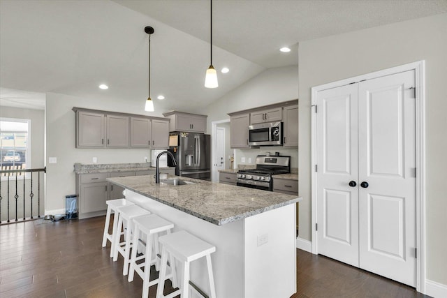 3901 Obsidian Dr, Champaign, IL 61822 - kitchen featuring stainless steel appliances, gray cabinetry, a sink, a breakfast bar area, and lofted ceiling