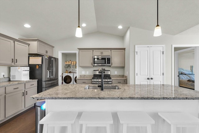 3901 Obsidian Dr, Champaign, IL 61822 - kitchen featuring stainless steel appliances, independent washer and dryer, gray cabinets, a sink, and vaulted ceiling