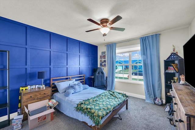 3901 Obsidian Dr, Champaign, IL 61822 - carpeted bedroom with a textured ceiling, ceiling fan, baseboards, and a decorative wall