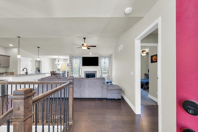 3901 Obsidian Dr, Champaign, IL 61822 - living room with a ceiling fan, dark wood-style floors, a fireplace, baseboards, and a chandelier