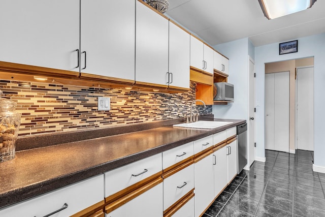 225 S Rohlwing Rd Unit 301, Palatine, IL 60074 - kitchen with appliances with stainless steel finishes, a sink, dark countertops, white cabinets, and dark tile patterned flooring
