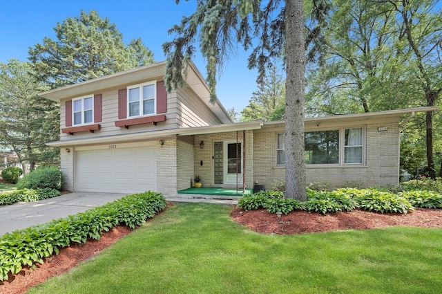 1022 W Ohio St, Glenwood, IL 60425 - split level home with brick siding, an attached garage, driveway, and a front yard
