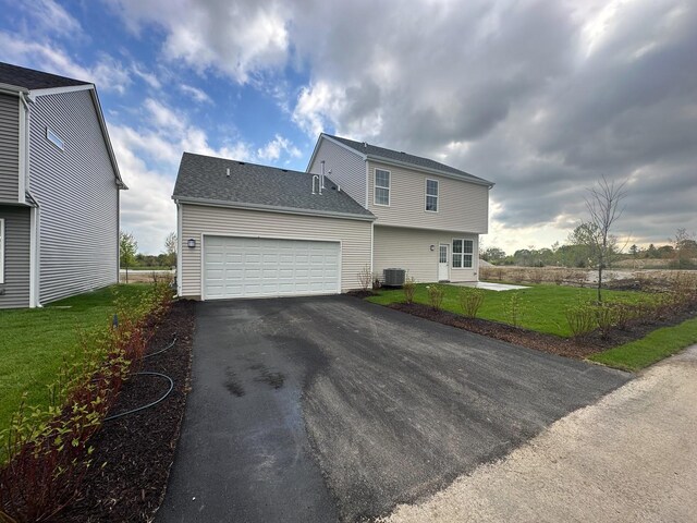 995 Celebration Dr, Aurora, IL 60504 - view of front facade with driveway, a garage, a front lawn, and cooling unit
