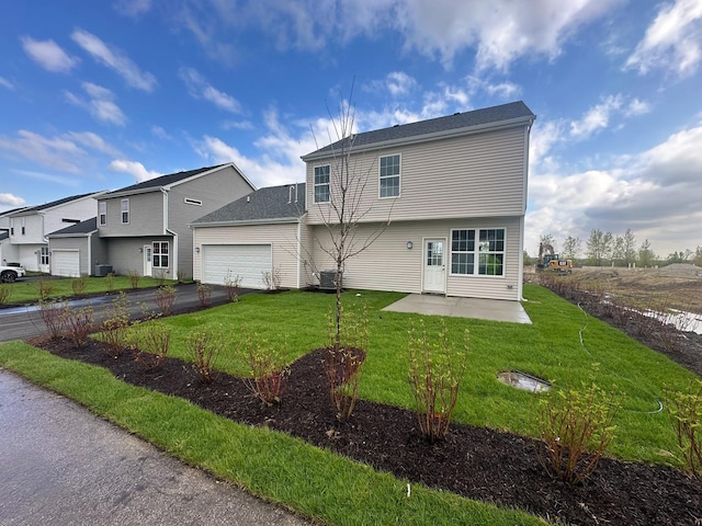 995 Celebration Dr, Aurora, IL 60504 - rear view of house with an attached garage, a lawn, asphalt driveway, and a patio