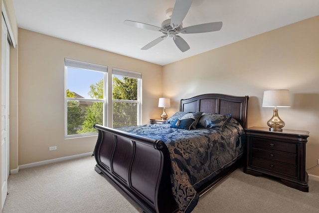 bedroom with light carpet, baseboards, and ceiling fan