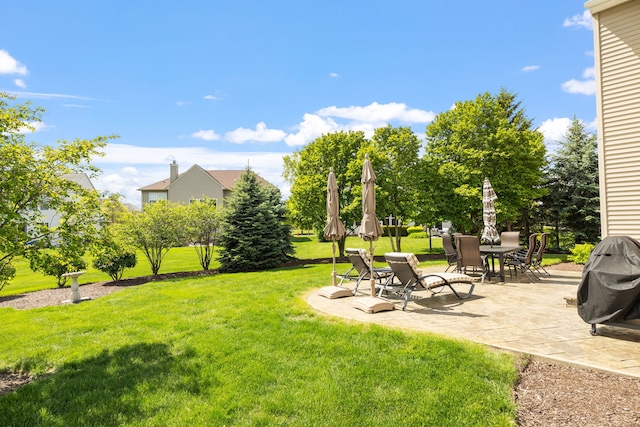 view of green lawn with a patio