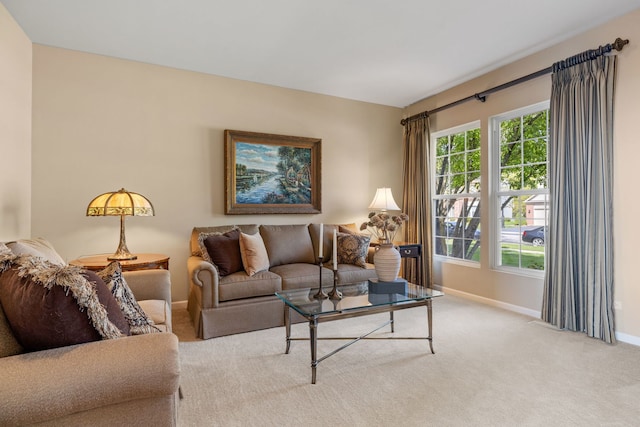 carpeted living area with baseboards