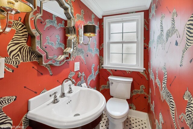 bathroom featuring a sink, toilet, baseboards, and ornamental molding