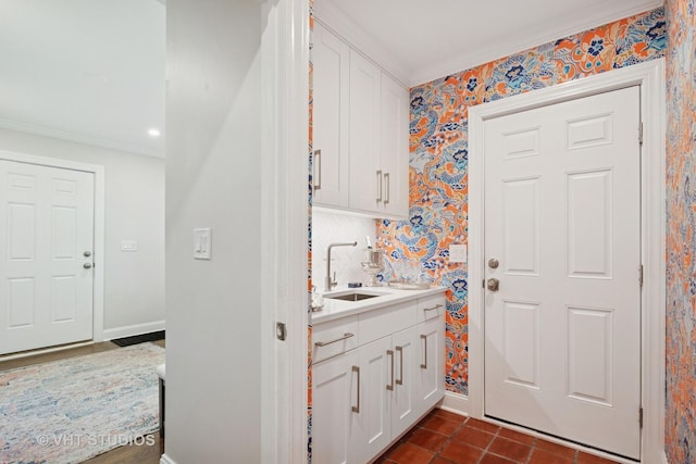 843 Chilton Ln, Wilmette, IL 60091 - laundry room with a sink, crown molding, wallpapered walls, dark tile patterned floors, and baseboards