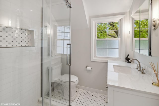 full bath featuring baseboards, toilet, a stall shower, vanity, and plenty of natural light
