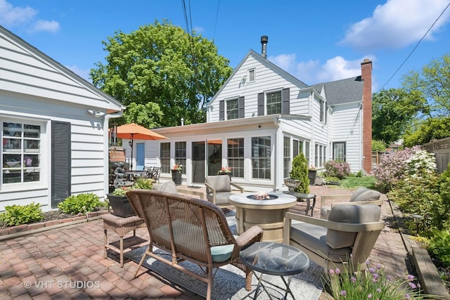 843 Chilton Ln, Wilmette, IL 60091 - rear view of house with an outdoor fire pit, a patio area, and a chimney