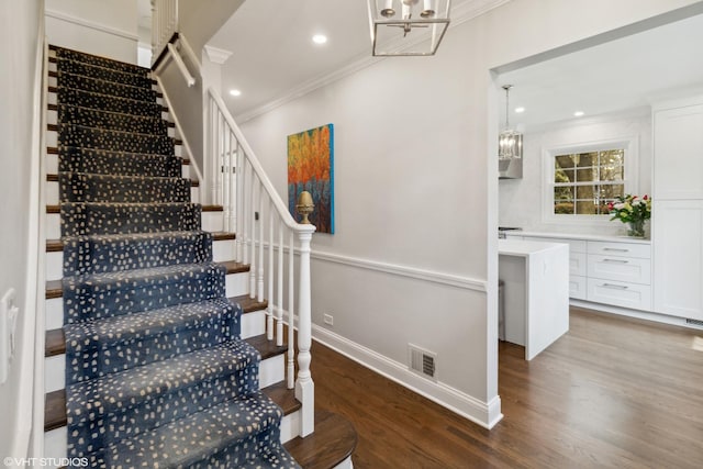 stairway featuring crown molding, wood finished floors, baseboards, a chandelier, and recessed lighting