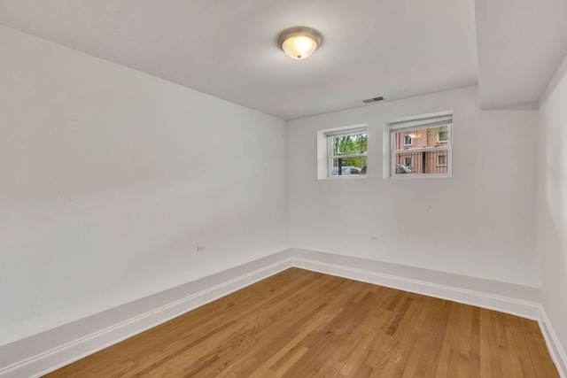 empty room featuring baseboards and light wood finished floors