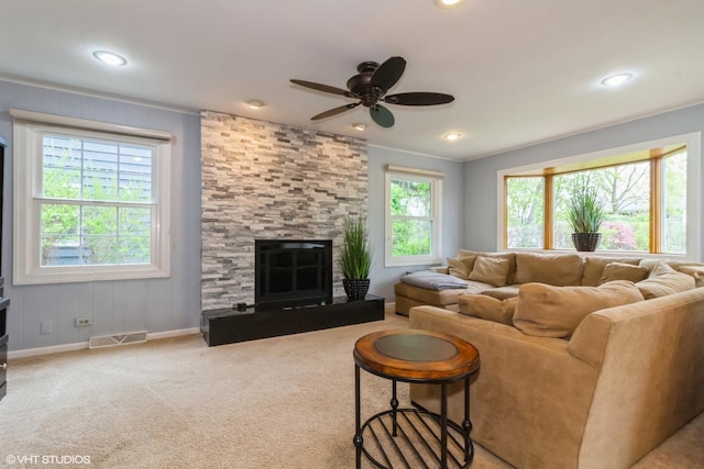 living area with a ceiling fan, baseboards, recessed lighting, carpet, and a stone fireplace