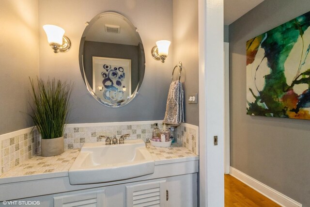 bathroom with vanity, tasteful backsplash, and wood finished floors