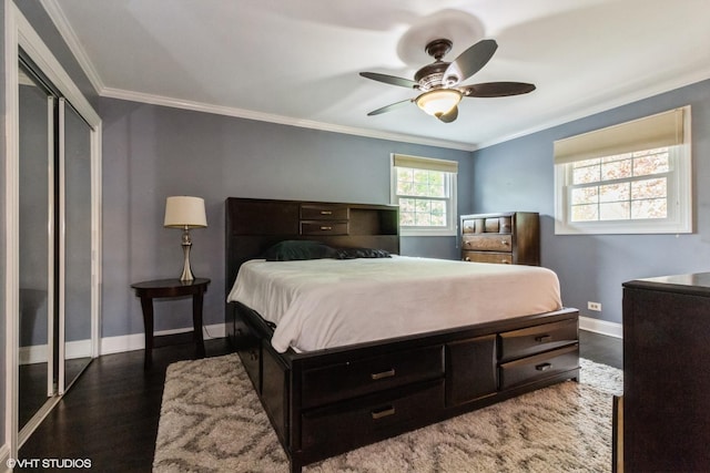 bedroom featuring crown molding, wood finished floors, baseboards, a ceiling fan, and a closet