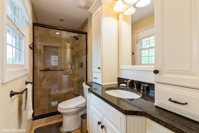 full bathroom featuring a shower stall, vanity, and toilet