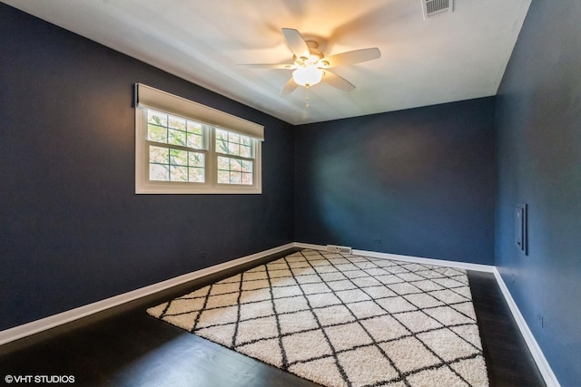 unfurnished room with a ceiling fan, wood finished floors, and baseboards